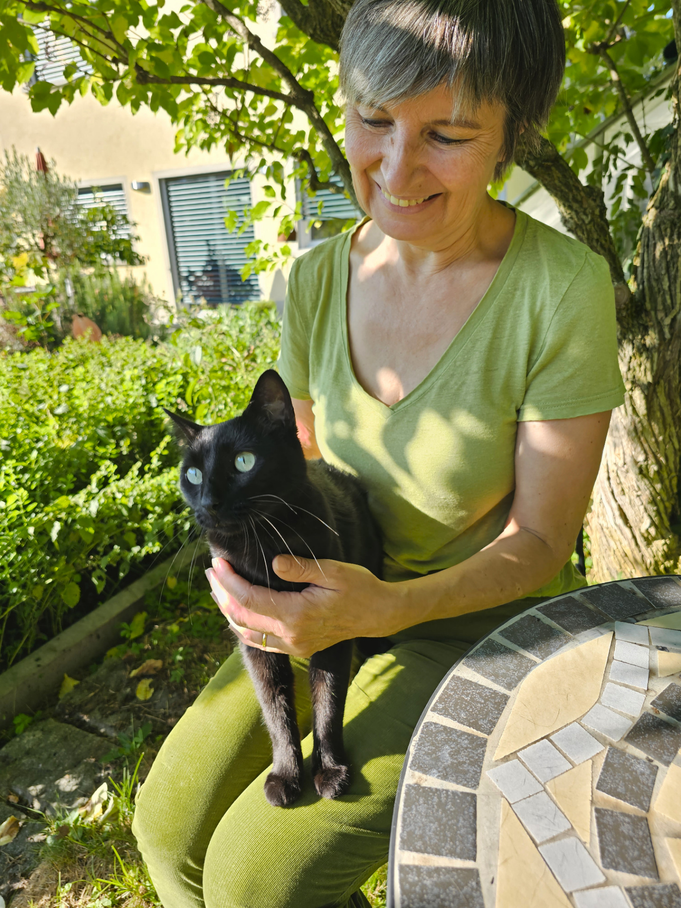 Portrait: Andrea Beck mit einer schwarzen Katze im Arm