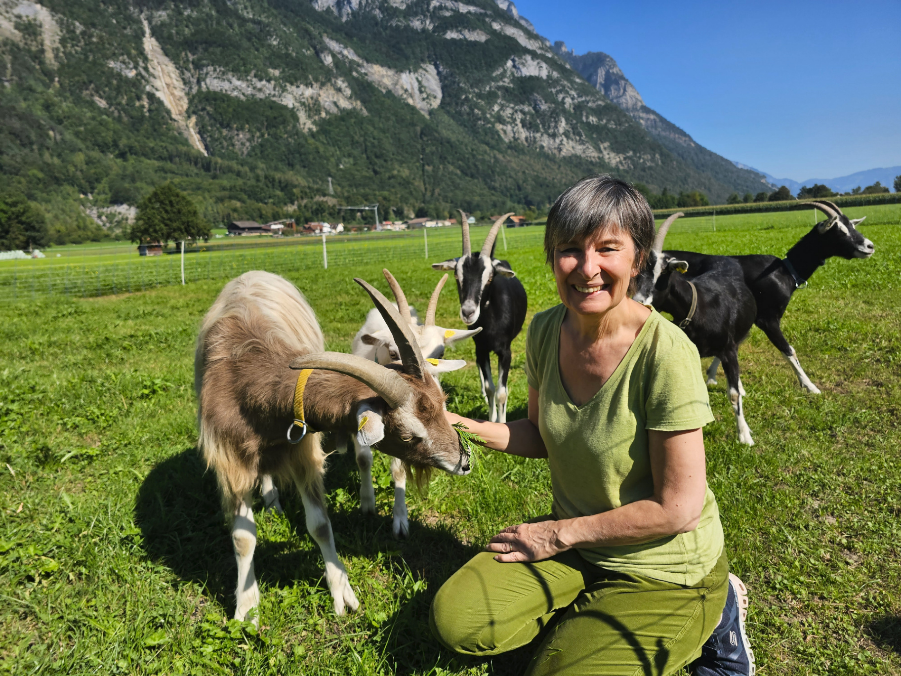 Andrea Beck lacht mit einer Gruppe Ziegen